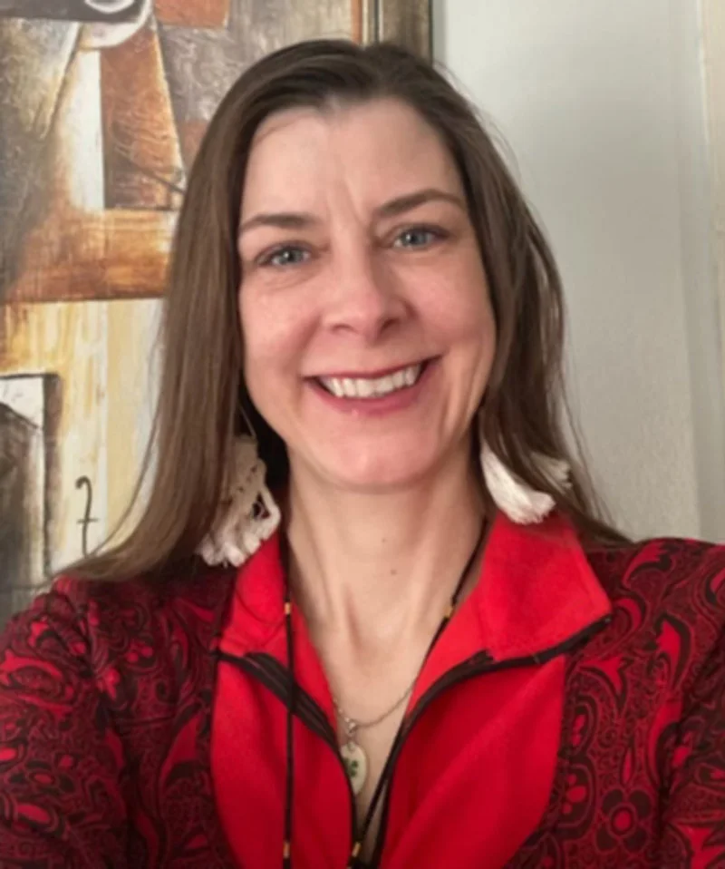 Delia C. smiling in a red and black top